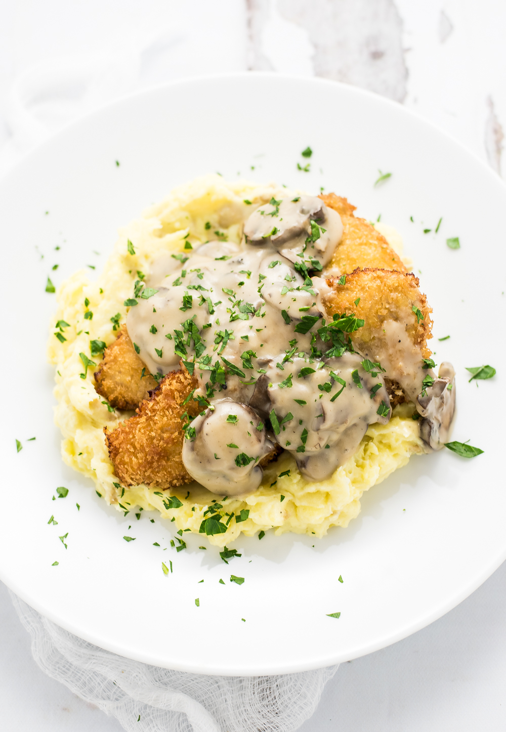 Pork Schnitzel with Mushroom Stout Gravy is a twist on a classic Austrian dish that is loaded with flavor and coated with crispiness!